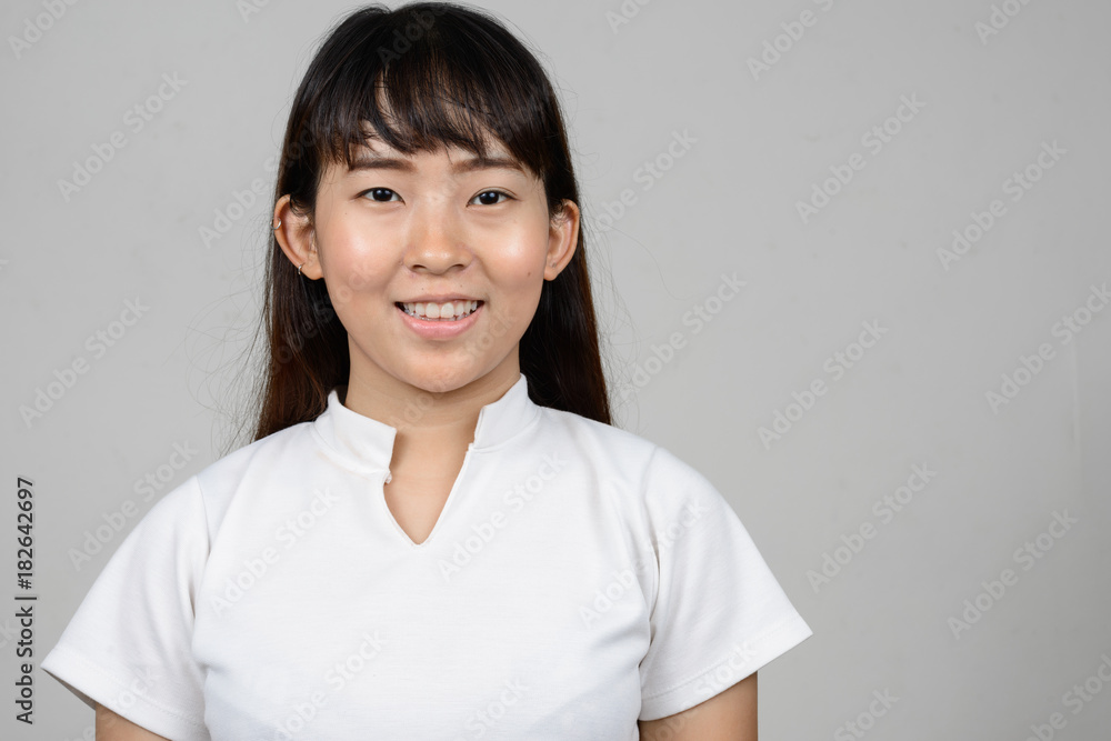 Portrait of beautiful young Asian woman against white background Portrait of beautiful young Asian woman against white background
