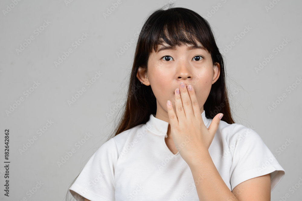 Portrait of beautiful young Asian woman against white background Portrait of beautiful young Asian woman against white background