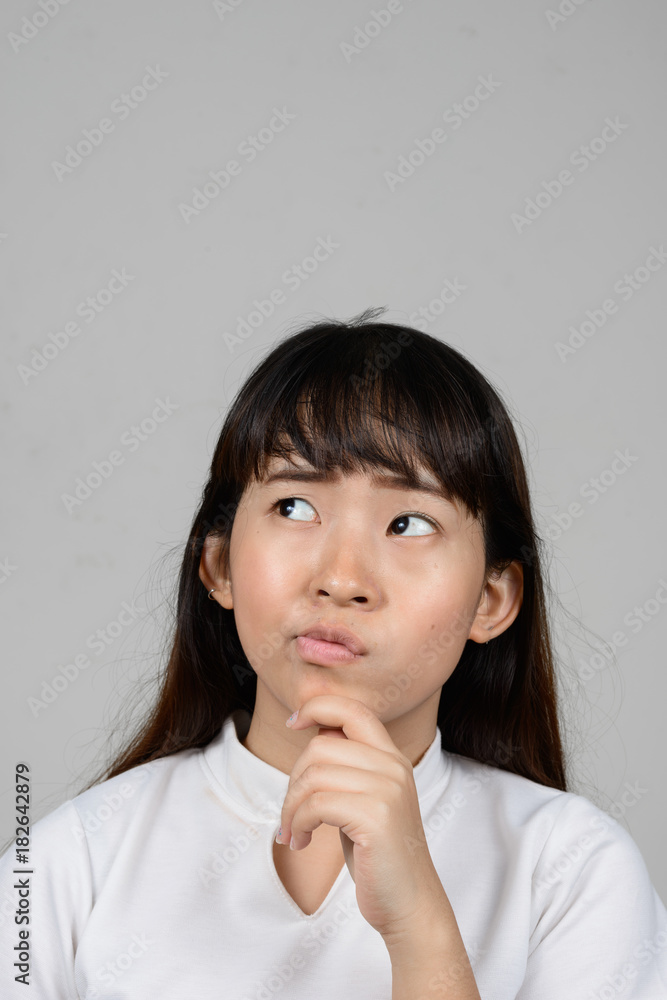 Portrait of beautiful young Asian woman against white background Portrait of beautiful young Asian woman against white background