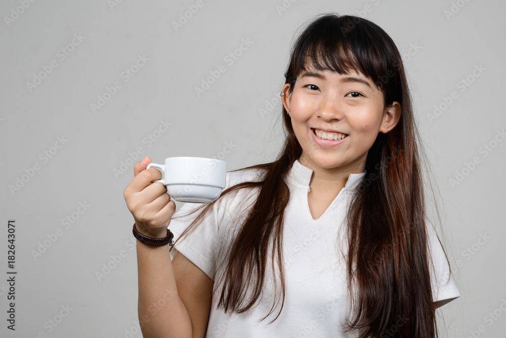 Portrait of beautiful young Asian woman against white background Portrait of beautiful young Asian woman against white background