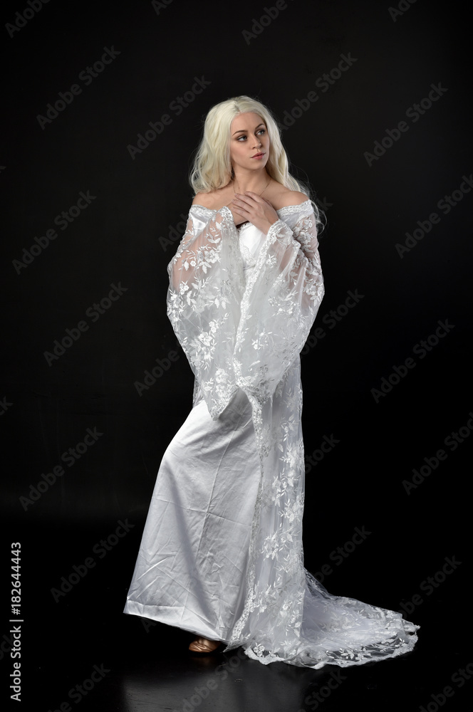 full length portrait of a blonde lady wearing beautiful lace gown, standing pose on black background. full length portrait of a blonde lady wearing beautiful lace gown, standing pose on black background.