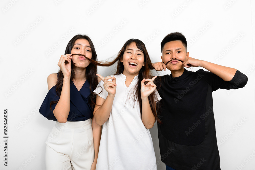 Group Of Three Young Asian Woman Indoors Against White Background Group Of Three Young Asian Woman Indoors Against White Background