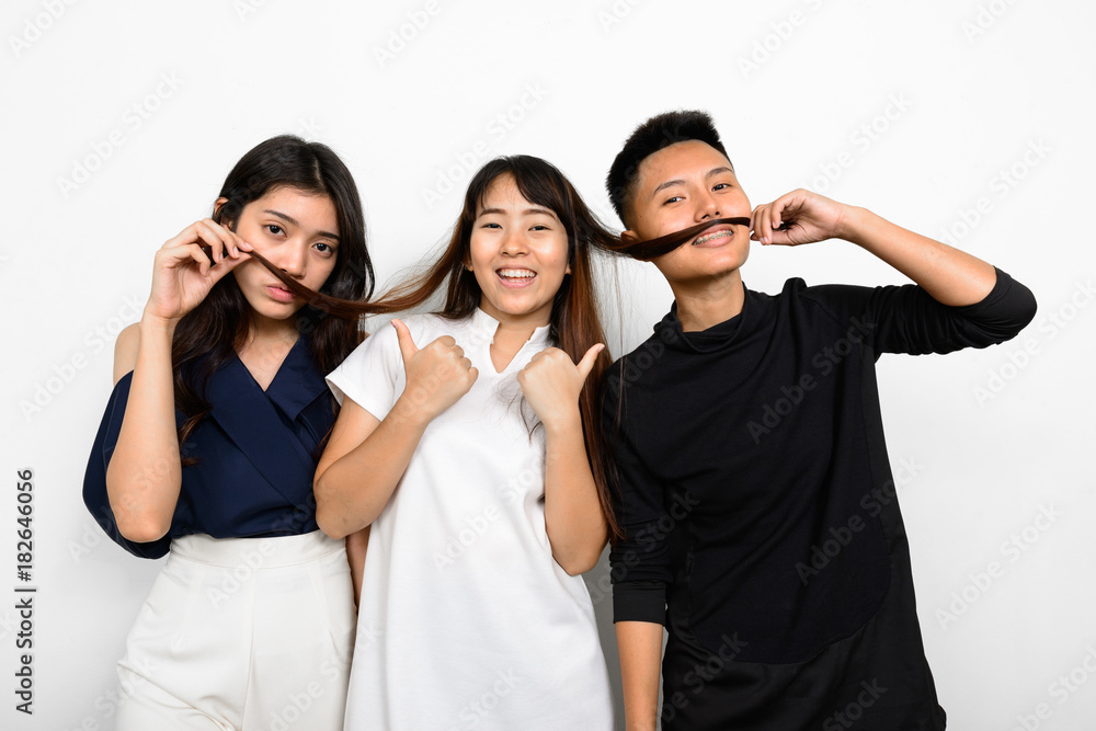Group Of Three Young Asian Woman Indoors Against White Background Group Of Three Young Asian Woman Indoors Against White Background
