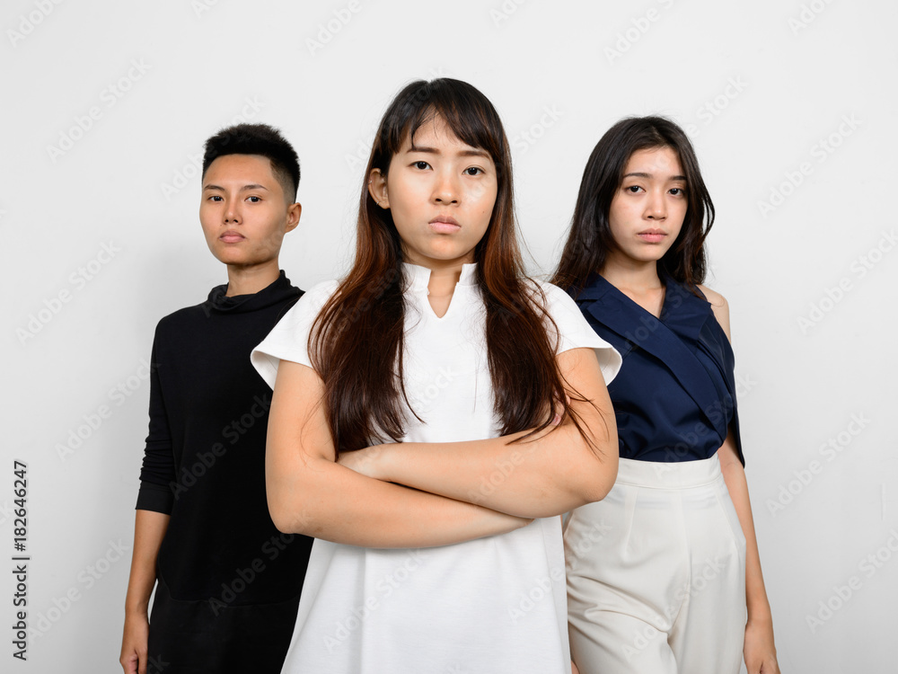 Group Of Three Young Asian Woman Indoors Against White Background Group Of Three Young Asian Woman Indoors Against White Background