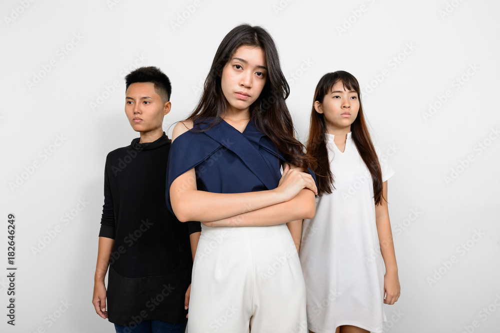 Group Of Three Young Asian Woman Indoors Against White Background Group Of Three Young Asian Woman Indoors Against White Background