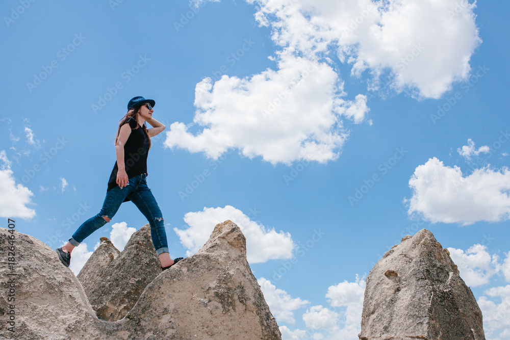 Young beautiful travel girl on top of a hill in Cappadocia, Turkey. Travel, success, freedom, achievement. She goes. Young beautiful travel girl on top of a hill in Cappadocia, Turkey. Travel, success, freedom, achievement. She goes.