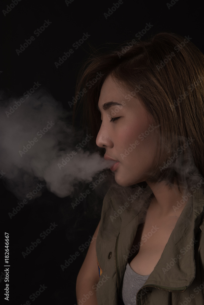 Asian women are smoking in the dark.