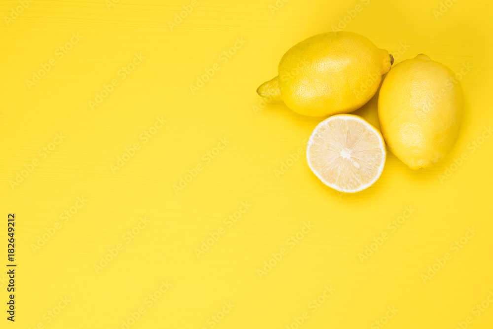 lemons and their half lie on a yellow background lemons and their half lie on a yellow background