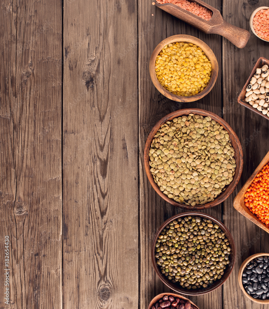 Set of various beans and colorful lentils in bowls and box on wooden background, top view with copy space Set of various beans and colorful lentils in bowls and box on wooden background, top view with copy space