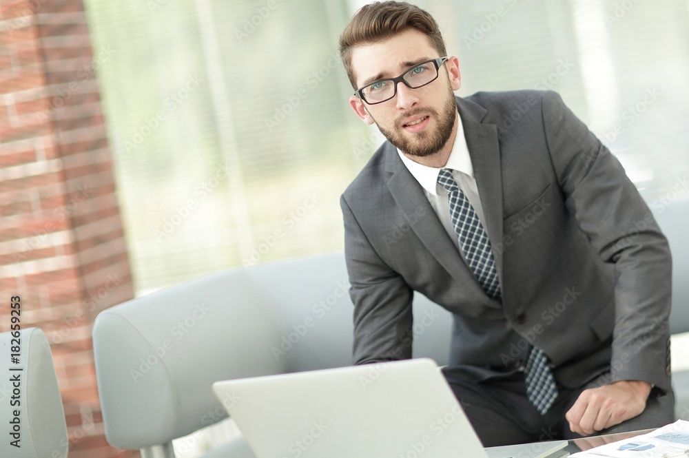 Portrait of a modern businessman sitting at his desk. Portrait of a modern businessman sitting at his desk.