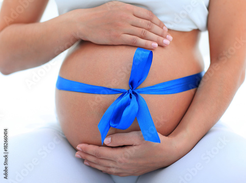 Wallpaper Mural closeup of a pregnant woman tying a blue ribbon on her belly Torontodigital.ca