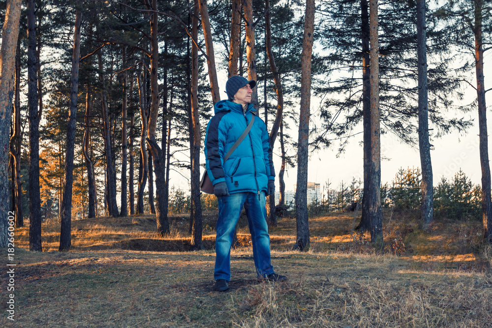 The man in the blue jacket enjoy the autumn nature. The concept of a healthy lifestyle. The man in the blue jacket enjoy the autumn nature. The concept of a healthy lifestyle.