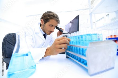 Chemist looking at test-tubes with blue liquids