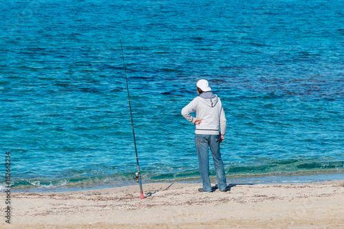 Man is fishing on the beach.