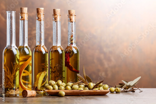 Green olives and bottles of olive oil .