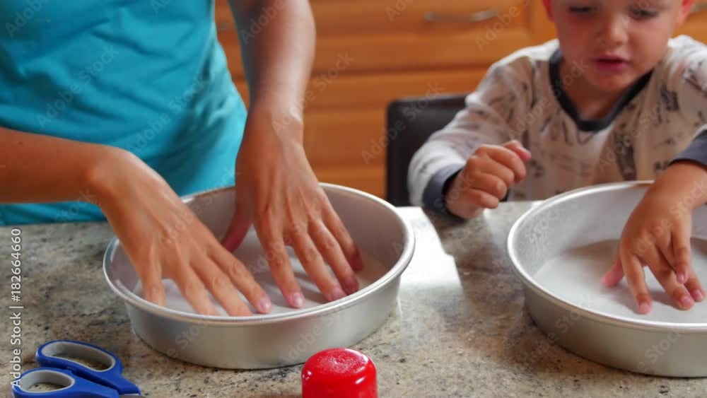 Mother makes a cake with her little boys in kitchen Mother makes a cake with her little boys in kitchen