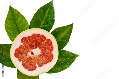 Cut grapefruit, fresh green foliage. Isolated top view.