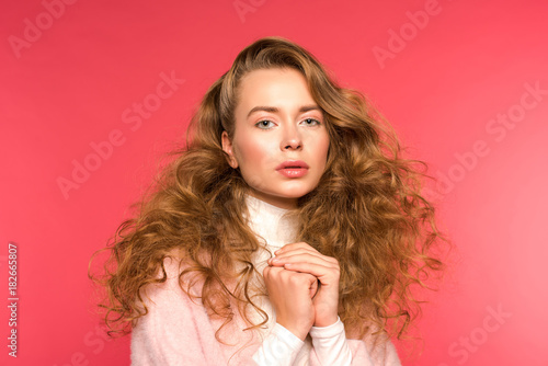 confident girl with curly hair isolated on red