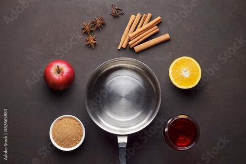 Ingredients for recipe of homemade mulled wine on brown stone table.