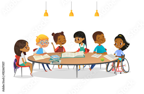 Smiling disabled girl in wheelchair and her school friends sitting around round table, reading books and talk to each other. Concept of inclusive activity. Cartoon vector illustration for banner.