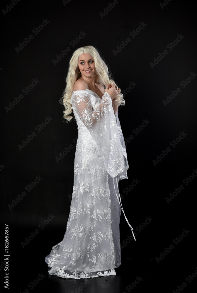 full length portrait of a blonde lady wearing beautiful lace gown, standing pose on black background. full length portrait of a blonde lady wearing beautiful lace gown, standing pose on black background.