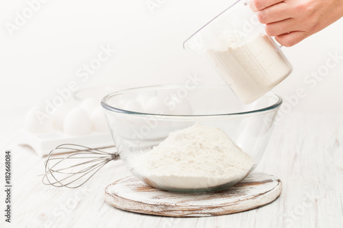 Flour in a Cup on a white table in the kitchen