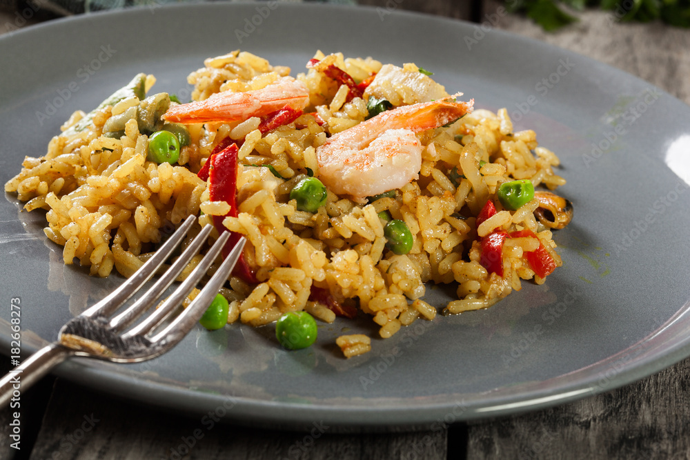 Traditional seafood paella with shrimp, fish and chicken seved in plate. Traditional seafood paella with shrimp, fish and chicken seved in plate.