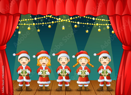 Group of children singing christmas carols on the stage