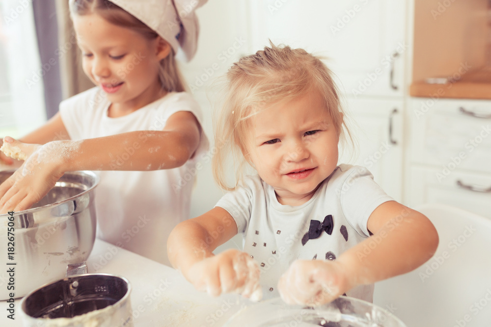 Cute little baby girl 2 years old cook apple pie for dinner. Kid prepares the dough at home in the kitchen. Healthy food at home. Cute little baby girl 2 years old cook apple pie for dinner. Kid prepares the dough at home in the kitchen. Healthy food at home.