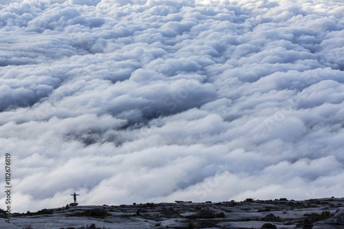 Person on cloud covered top of Mount Kinabalu, Malaysia