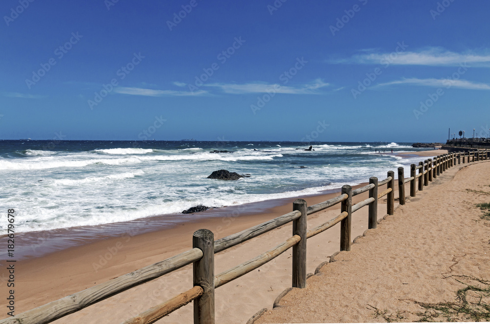 Wooden Pole Barrier on Beachfront Against Coastal  Landscape