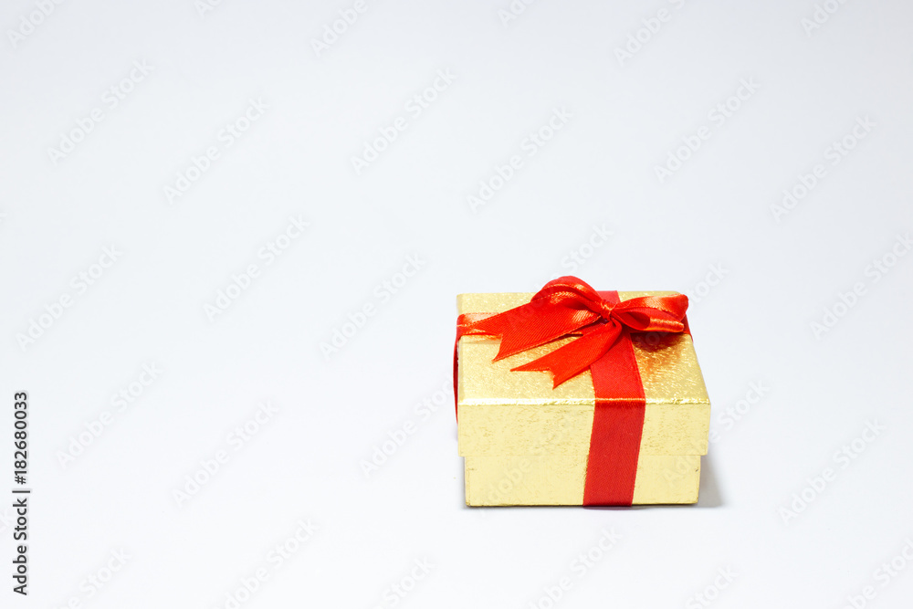 Obraz premium Gloden gift box with red bow on white background