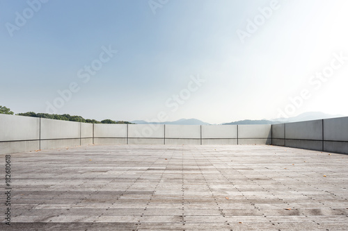empty marble floor with beautiful lake in blue sky © zhu difeng