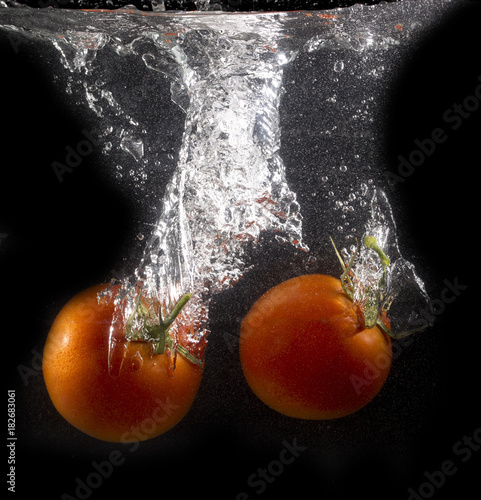 tomato in water on a black background