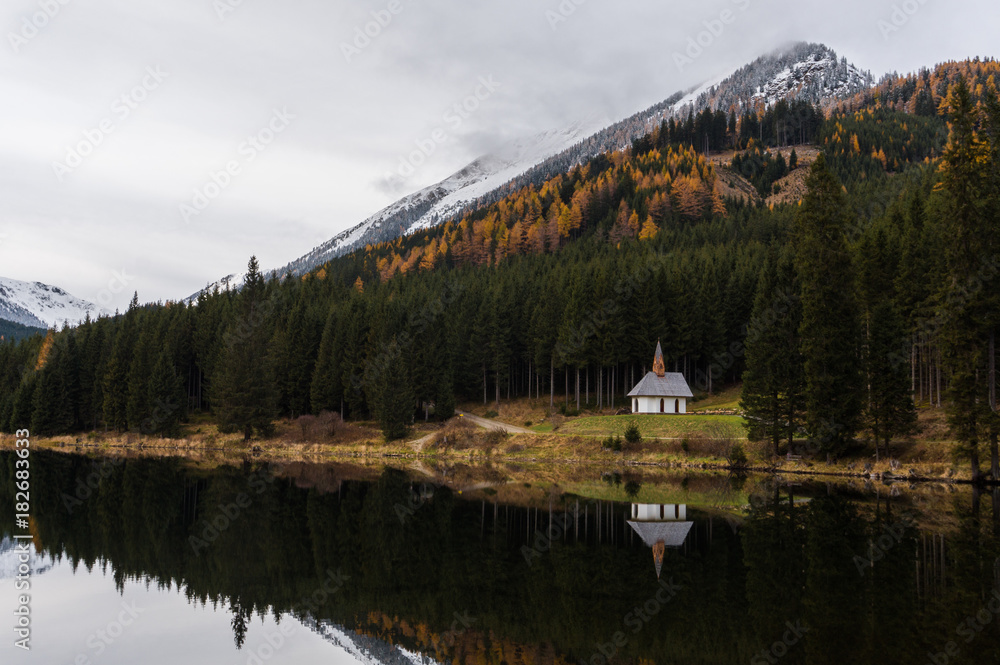 Pretty, small chapel on the shore of lake Ingering with a stunning autumn background