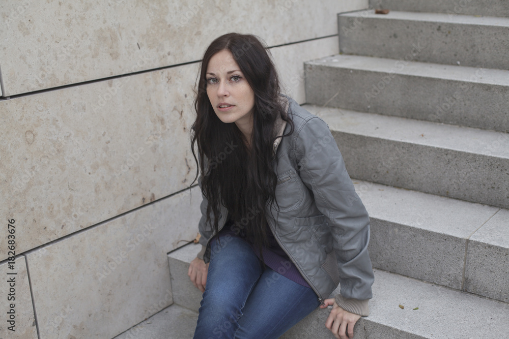 Young woman sitting on a staircase looking at camera, Munich, Bavaria, Germany Young woman sitting on a staircase looking at camera, Munich, Bavaria, Germany