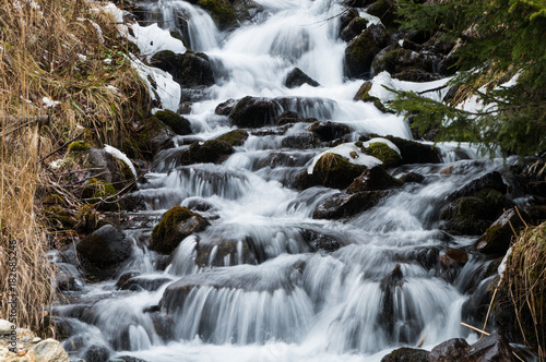 Majestic small stream cascading down a mountain slope in the Austrian Alps (long exposure)