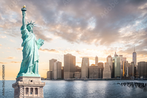 The Statue of Liberty with Lower Manhattan background in the evening at sunset, Landmarks of New York City, USA © spyarm