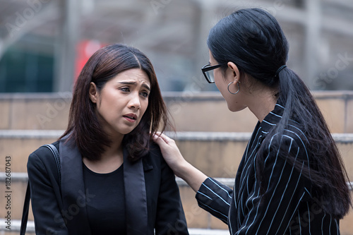 Businesswoman with hand on shoulder of colleague, consoling businesswoman stressed,suffering in the problem at step office. photo