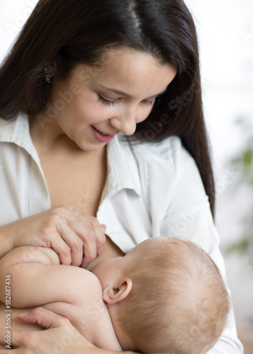 Young mother feeding breast...