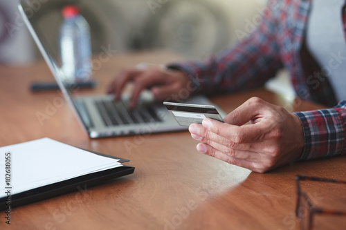 Man holding credit card and using laptop. Online shopping