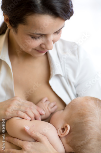 Young mother feeding breast...