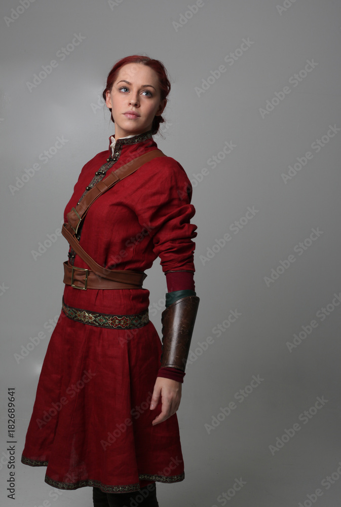 portrait of a red haired girl wearing medieval warrior outfit, studio  background. Stock Photo | Adobe Stock