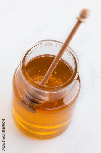 jar of honey with honeycomb on white