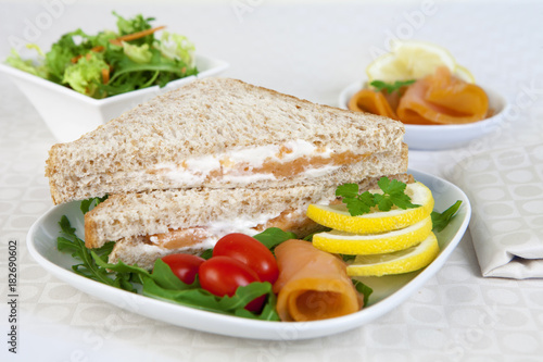 Sandwich with Smoked Salmon served on a white dish like an apetizer