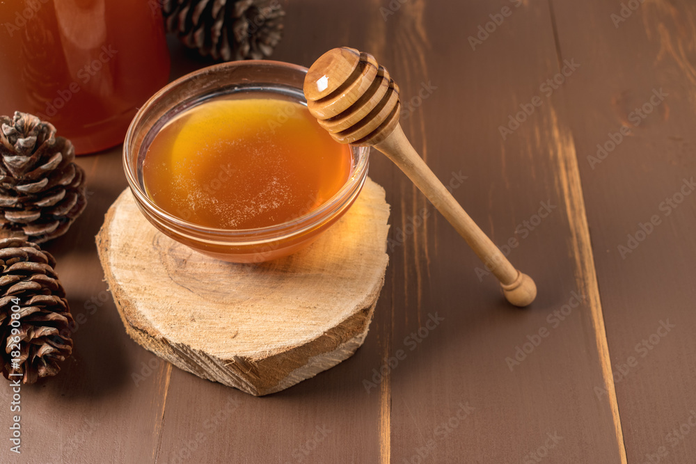 Honey with wooden honey dipper in jar on wooden table Honey with wooden honey dipper in jar on wooden table