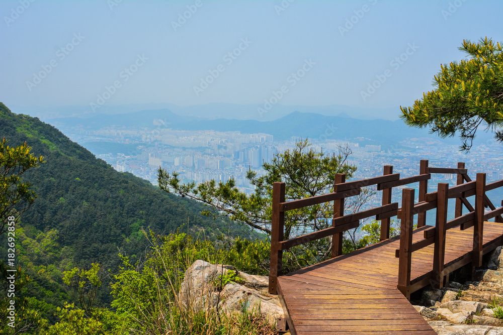 Staircase down a mountain side overlooking a city.