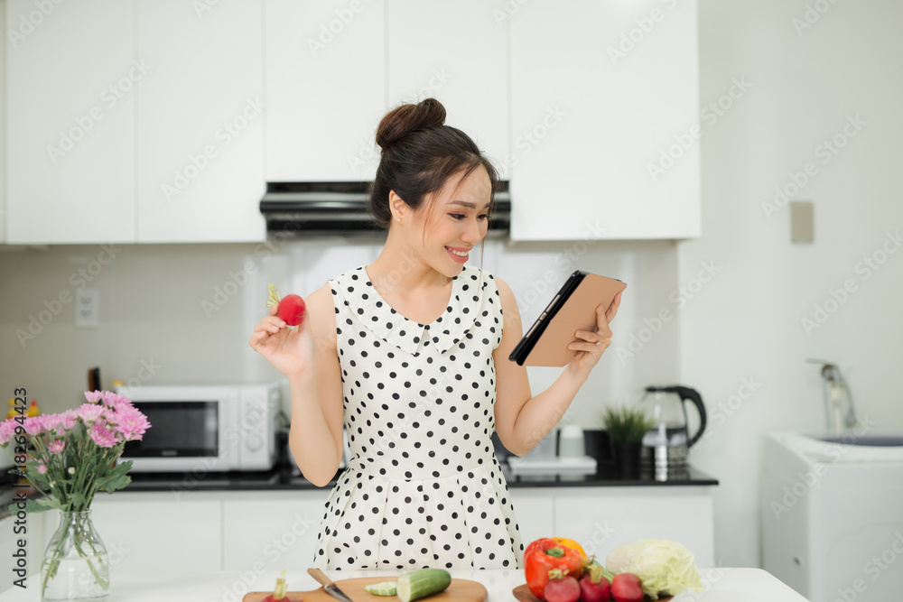 Happy cooking. Young asian woman cutting vegetables for salad in the kitchen Happy cooking. Young asian woman cutting vegetables for salad in the kitchen