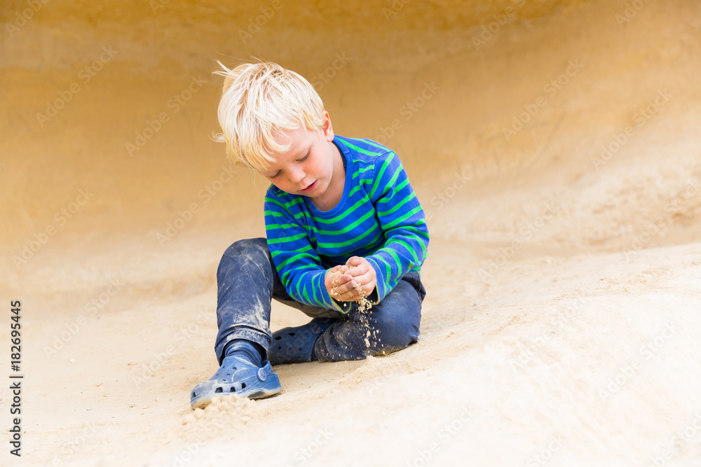 4 years old boy playing with sand on the beach of Portals Vells, MR, near Magaluf, Majorca, Balearic Islands, Spain, Europe 4 years old boy playing with sand on the beach of Portals Vells, MR, near Magaluf, Majorca, Balearic Islands, Spain, Europe