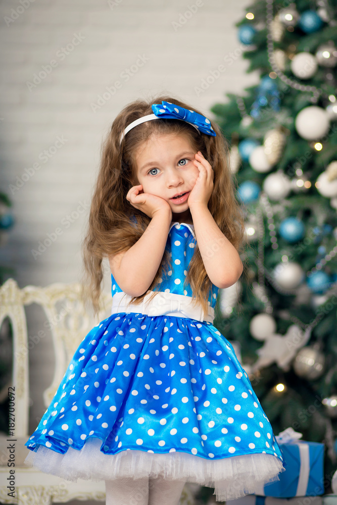 beautiful girl in a blue dress near a Christmas tree beautiful girl in a blue dress near a Christmas tree